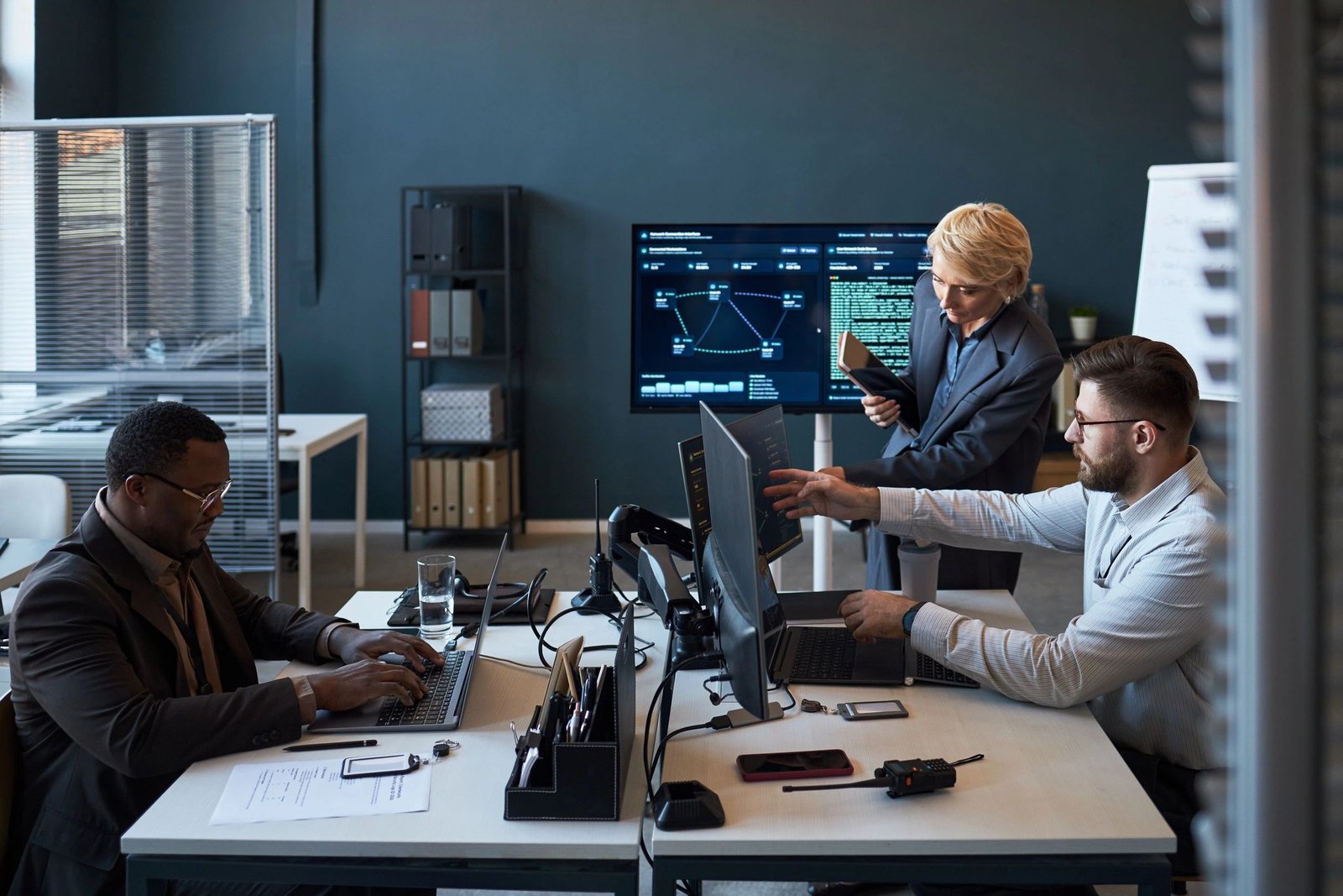 Cybersecurity and IT consulting team reviewing dashboards in a collaborative workspace